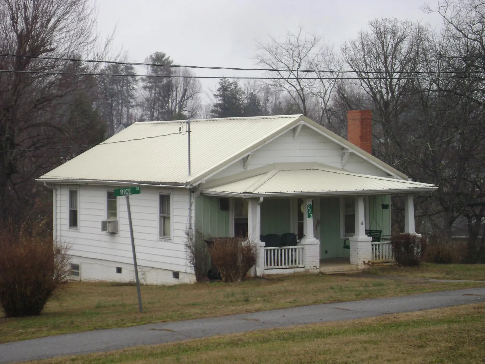 White metal roof on a craftsman bungalow at a street corner in East Leroy